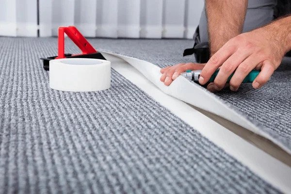 Installer laying carpet